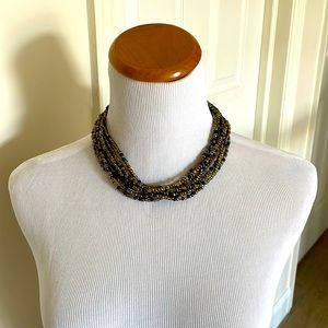 Neutral colors brown black and gray seed bead necklace with a  button closure.